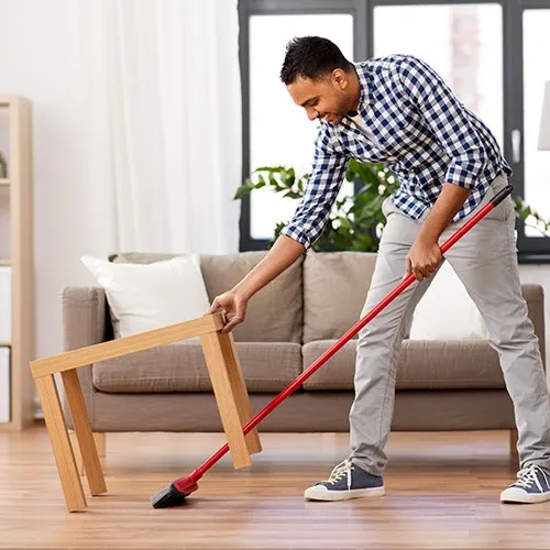 Smiling man cleaning vinyl flooring | Shans Carpets And Fine Flooring