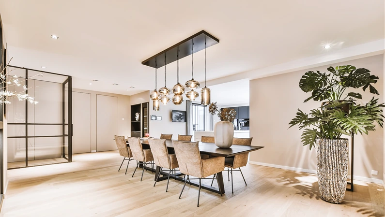 Spacious minimalist style dining room with table and chairs in modern apartment and wooden floor