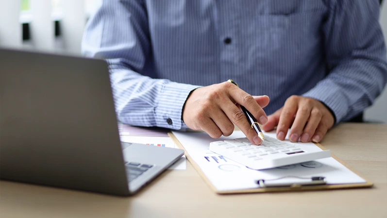 Close up bankers are calculating finances using calculators for financial planning and lending.