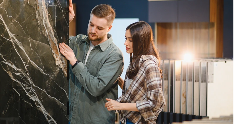 Young couple comparing decorative marble tile options for new constructio