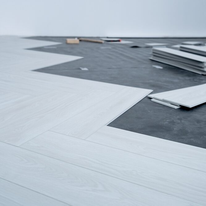 A,Man,Lays,A,Quartz,Laminate,On,The,Floor.,Renovation