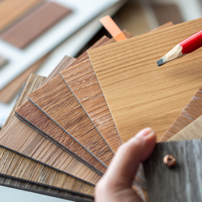 Interior,Designer,Hand,Holding,Sample,Stack,Of,Vinyl,Wood,Sheet